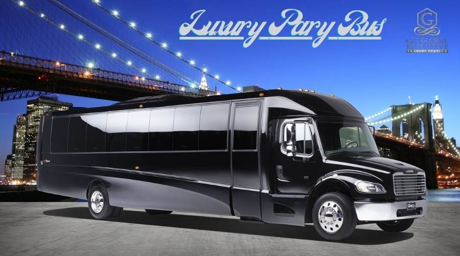 Black luxury party bus Magnolia parked in front of a suspension bridge at night.